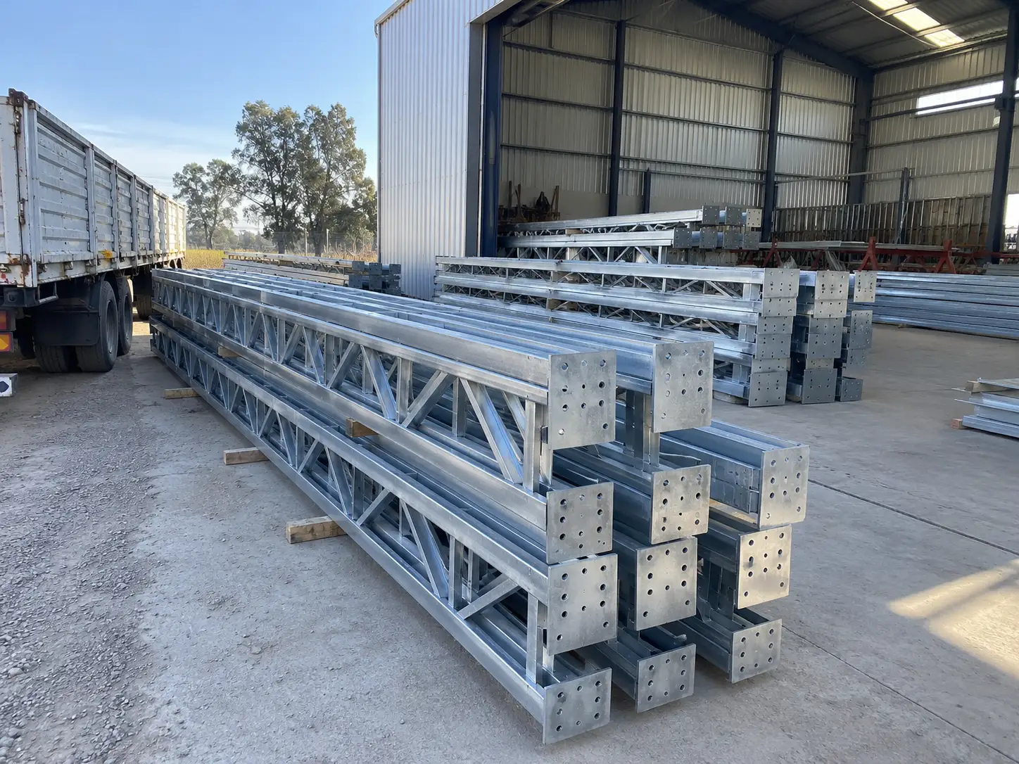 Pórticos galvanizados apilados en el taller listos para cargar al camión